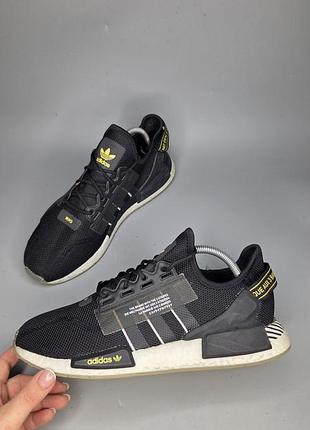 Черные кроссовки adidas nmd_r1 v2 с характерными желтыми надписями и белой подошвой boost