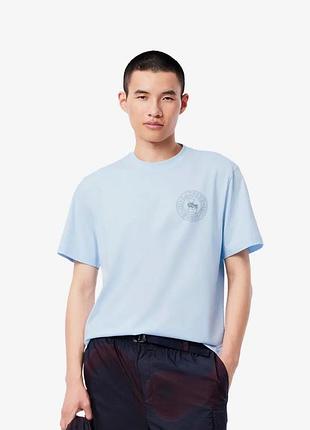 Светло-голубая футболка lacoste с круглым логотипом на груди.