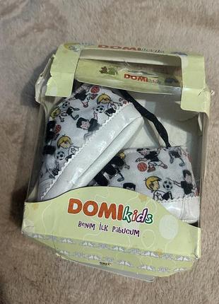 Дитячі текстильні пінетки бренду domikids із серії «benim i̇lk pabucum» (моє перше взуття), виконані у вигляді білих кедів із яскравим принтом