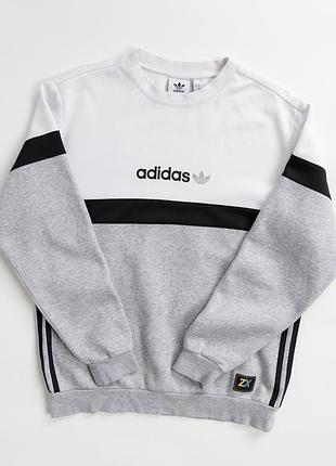 Чоловічий світшот adidas у стильному поєднанні білого, світло-сірого та чорного кольорів. модель має класичний, круглий комір, довгі рукави з еласти