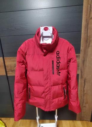 Красный пуховик спортивного бренда adidas.