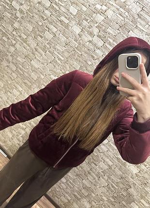 Куртка бордового кольору виконана з м'якого оксамитового матеріалу (велюру) з капюшоном,застібкою на блискавку й щільними манжетами на рукавах.