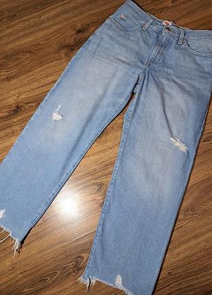 Вільні джинси levi's у світлому відтінку з ефектом потертостей, невеликими прорізами на штанинах та необробленим, розпатланим низом