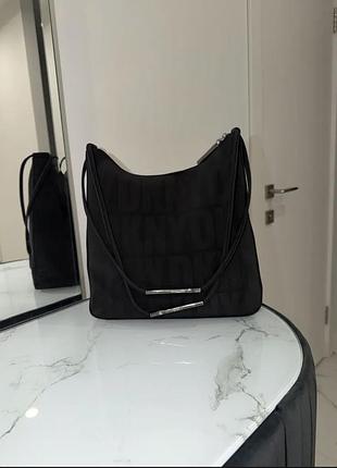 Оригінальна сумка dkny з канвасу чорного кольору, з фірмовим повторюваним логотипним візерунком та сріблястими акцентами на ручці.