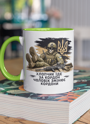 Чашка керамічна з принтом "хлопчик їде за кордон чоловік змінює кордони" 330 мл, біла з зеленою ручкою