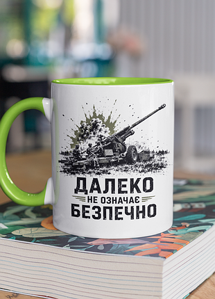 Чашка керамічна з принтом "далеко не означає безпечно" 330 мл, біла з зеленою ручкою