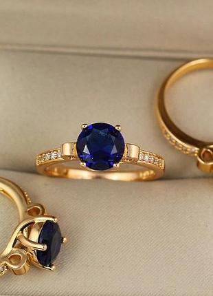 Кільце xuping jewelry з синім каменем 8 мм і дрібними фіанітами з боків р19 золотисте