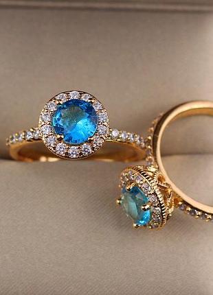 Кольцо xuping jewelry голубой камень с мелкими фианитами по кругу р 18 золотистое