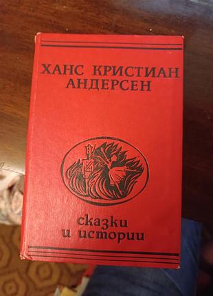 Книга ханса кристиана андерсена «сказки и истории» в красном твердом переплете.