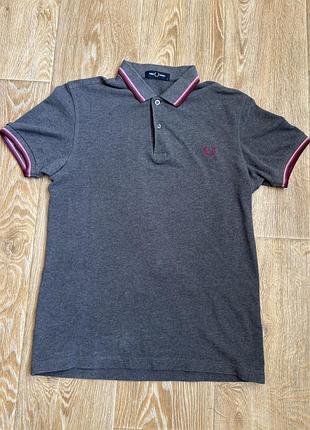 Сіра футболка поло від fred perry з характерними подвійними рожевими смужками на комірі та манжетах