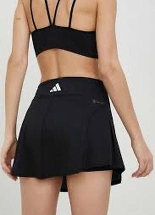 Чёрная спортивная юбка-шорты от adidas с фирменным логотипом на поясе.