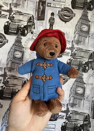 М'яку іграшку ведмедик паддінгтон (paddington bear) у його фірмовому синьому пальті з накл...