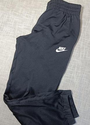 Чорні спортивні штани nike з білим логотипом на лівому стегні та манжетами знизу. підліткові спортивні штани nike на зріст 137-147 см