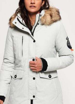 Женская куртка-парка superdry ashley everest с пушистым искусственным мехом на капюшоне и круглым фирменным логотипом на рукаве.