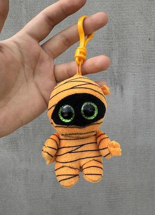Мягкую игрушку-брелок ty beanie boo's в виде оранжевой мумии по имени «mask»