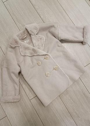 Дитяча двоборна дублянка бренду river island (лінійка river island mini). виконана з м'якого штучного матеріалу ніжного бежево-рожевого відтінку