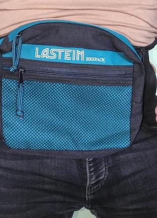 Спорт стильна чорна поясна спортивна сумка (бананка) бренду lastein bikepack бірюзовими чи синіми вставками та додатковим тримачем для пляшки .