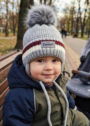 Дитяча тепла в'язана шапка з помпоном та зав'язками (розмір 44-48 см, 9 міс – 2 роки)