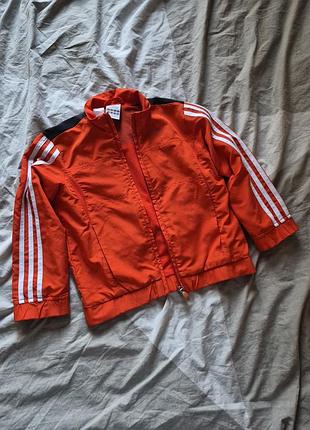 Красная спортивная куртка-ветровка (олимпийка) бренда adidas с белыми полосками на рукавах и черными вставками на плечах