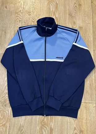 Вінтажна олімпійка adidas виробництва південної кореї з матеріалу складу 70% поліестер та 30% котон випущена у 1980-х років.