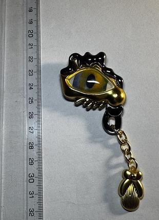 Брошка для жінок у стилі schiaparelli в сюрреалістичному стилі, око з підвіскою, золотиста, чорна