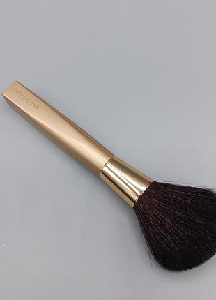 Пензлик для макіяжу від бренду estée lauder із золотистою ручкою та м'яким темним ворсом.