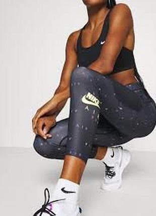 Чорні жіночі спортивні легінси бренду nike з яскравим кольоровим принтом та повторюваним написом «air» по всій поверхні. розмір вказано м.