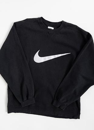 Стильний, вінтажний світшот nike у класичному, чорному кольорі з великим, контрастним swoosh на передній частині. мінімалістичний дизайн добре переда