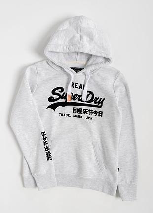 Жіноче худі superdry у світло-сірому кольорі з великим, контрастним, фірмовим принтом на передній частині. графіка поєднує характерний
