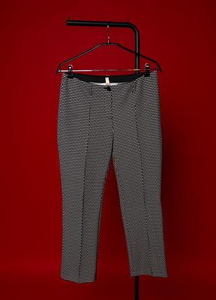Стильні, жіночі штани marc cain із виразним, чорно-білим, геометричним візерунком. модель має елегантний, прямий крій, комфортну посадку та лаконічний