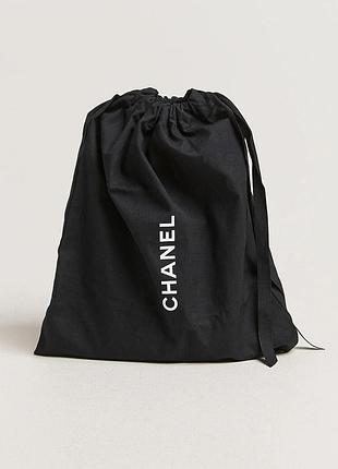 Черный текстильный брючок (мешочек для хранения) бренда chanel с белой вертикальной надписью