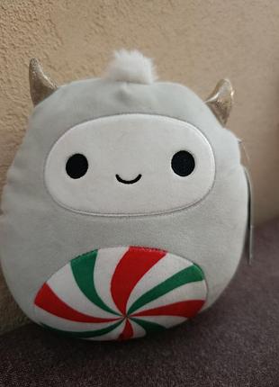 Игру плюшевый етти носса из коллекции squishmallows с рисунком мятной конфеты на животе.