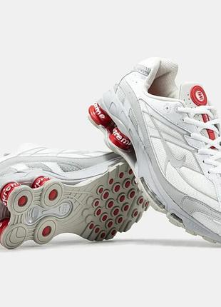 Кроссовки nike x supreme shox ride 2 sp "white/red" в белом цвете с красными амортизационными колонками и красным брендингом supreme на язычке