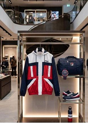 Пуховик бренда fila с ярким принтом с капюшоном и множеством карманов( из нюансов отсутствие снизу шнурков )