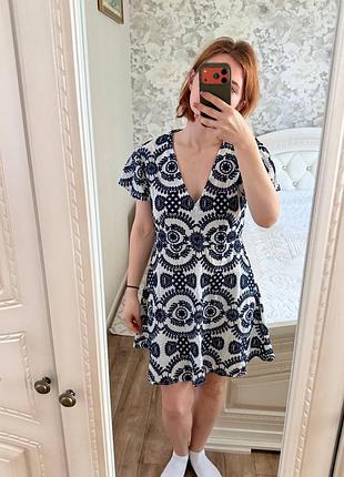 Коротка біла сукня з синім візерунком та v-подібним вирізом від prettylittlething
