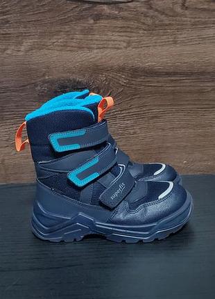 Детские зимние ботинки модели superfit snow max с мембраной gore-tex в синем цвете с голубыми и оранжевыми акцентами.