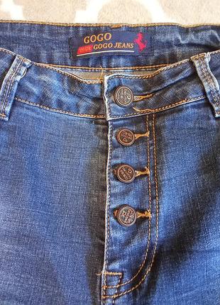 Сині жіночі джинси бренду gogo jeans із застібкою на ґудзиках-болтах.