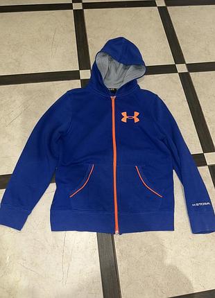 Синя спортивна зіп-худі від under armour, яка виділяється яскравим помаранчевим замком та фірмовим логотипом на грудях