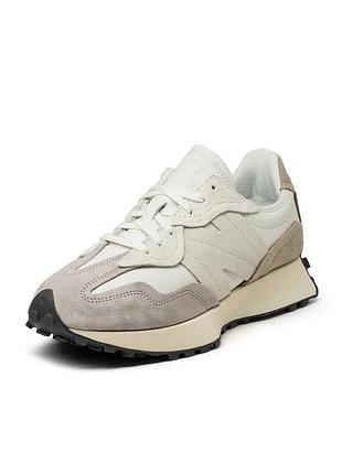 Кросівки new balance 327 у світлому забарвленні sea salt, які можна впізнати за фірмовим великим логотипом «n» із фактурної замші на бічній панелі.