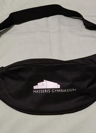 Черна поясна сумка (бананка) с белым логотипом и надписью «hasseris gymnasium».