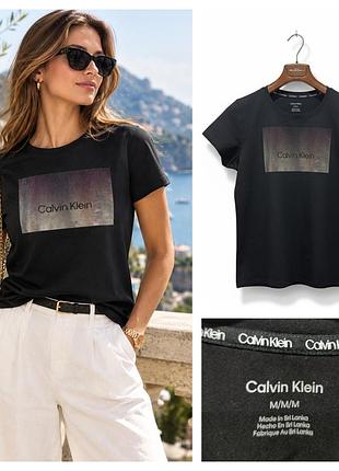 Черная футболка от calvin klein украшена фирменным прямоугольным принтом с градиентным пейзажем и надписью по центру. размер м.