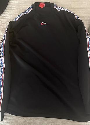 Чорний лонгсліф nike taped longsleeve top  з фірмо  вими лампасами на рукавах та міні-логотипом по центру горловини