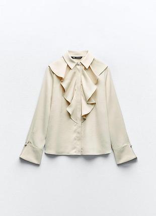 Элегантная бежевая блузка от бренда zara с объемными рюшами (жабо) спереди и декоративными пуговицами со стразами на манжетах.
