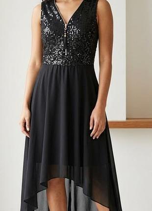 Вечернее платье без рукавов с блестящим верхом, украшенным пайетками, и асимметричной шифоновой юбкой.