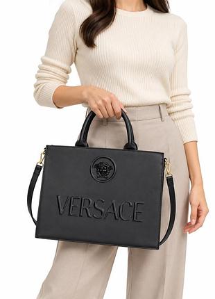 Чорна жіноча сумка з написом versace та знімним плечовим ременем
