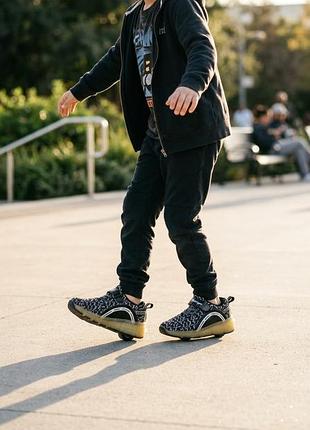 Детские кроссовки-ролики (wheelie/roller sneakers) бренда aimoge черно-белого цвета с led-подсветкой и встроенным колесом в пятке.