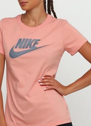 Розовая футболка nike с крупным фирменным логотипом и надписью на груди.
