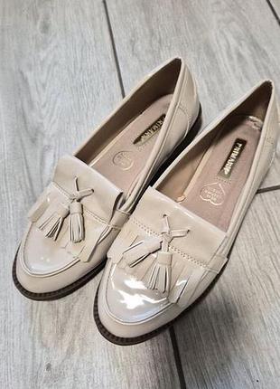 Светлые лаковые лоферы с кисточками от бренда primark