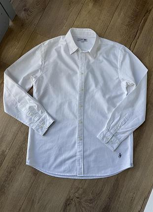 Біла сорочка із колаборації uniqlo і jw anderson (модель oxford oversized з характерною вишивкою у вигляді фірмового якоря jw anderson