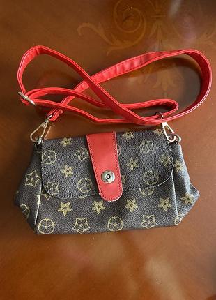 Жіноча сумка-крос боді у стилі бренду louis vuitton (коричнева канва з монограмами та червоним ремінцем і клапаном).
